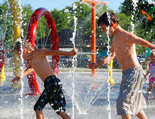 Group of Children playing in water jets 